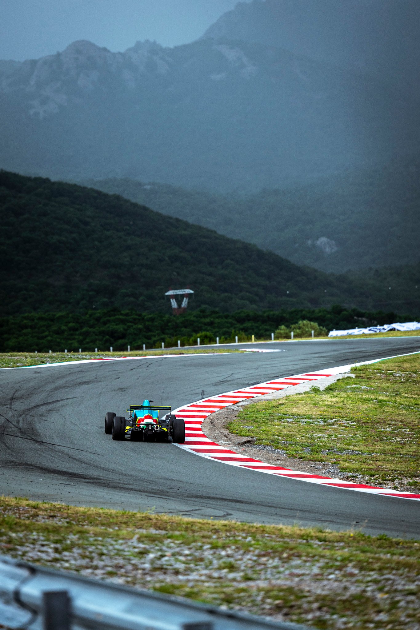 Formula car driving through a mountain circuit