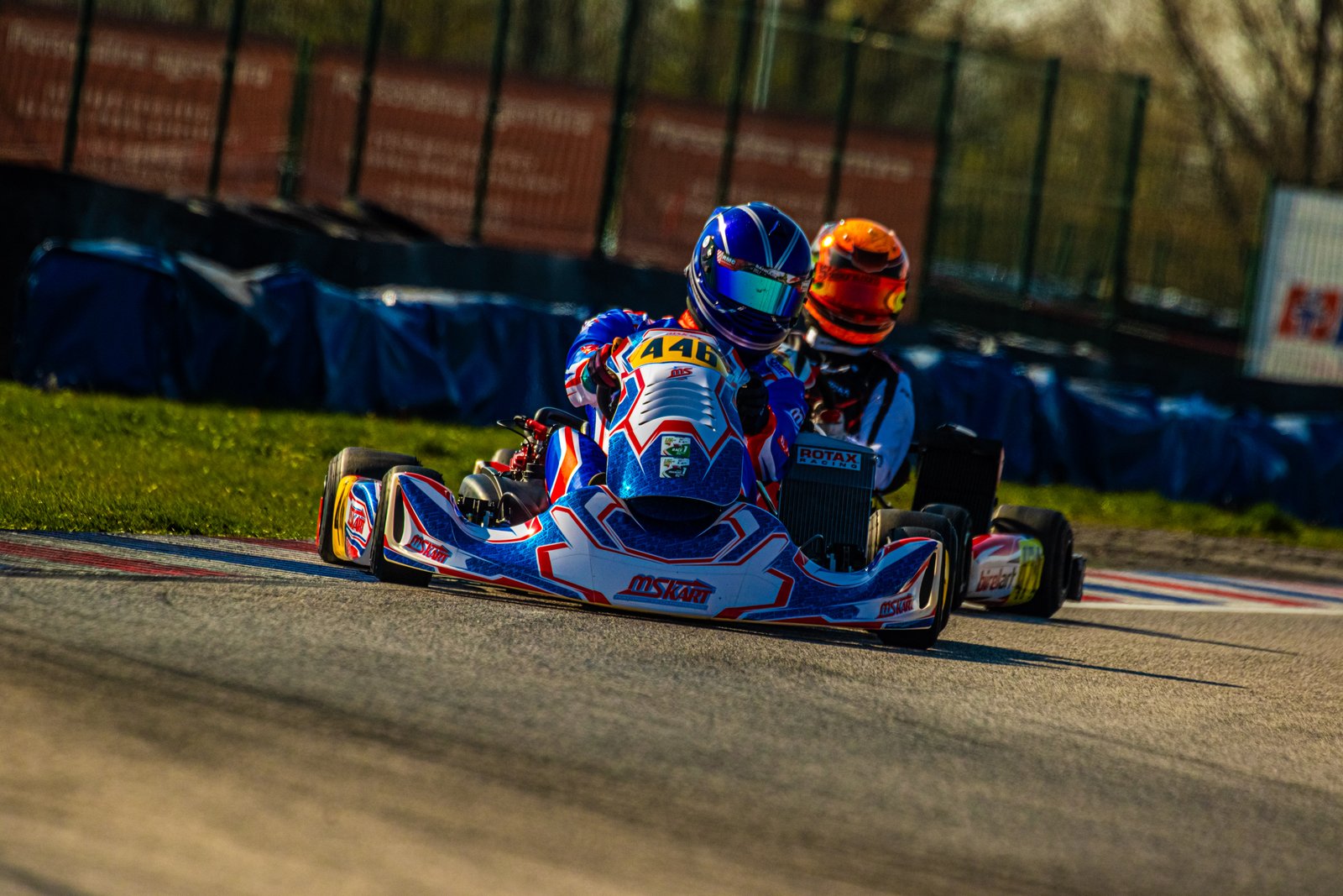 Two karting drivers racing closely